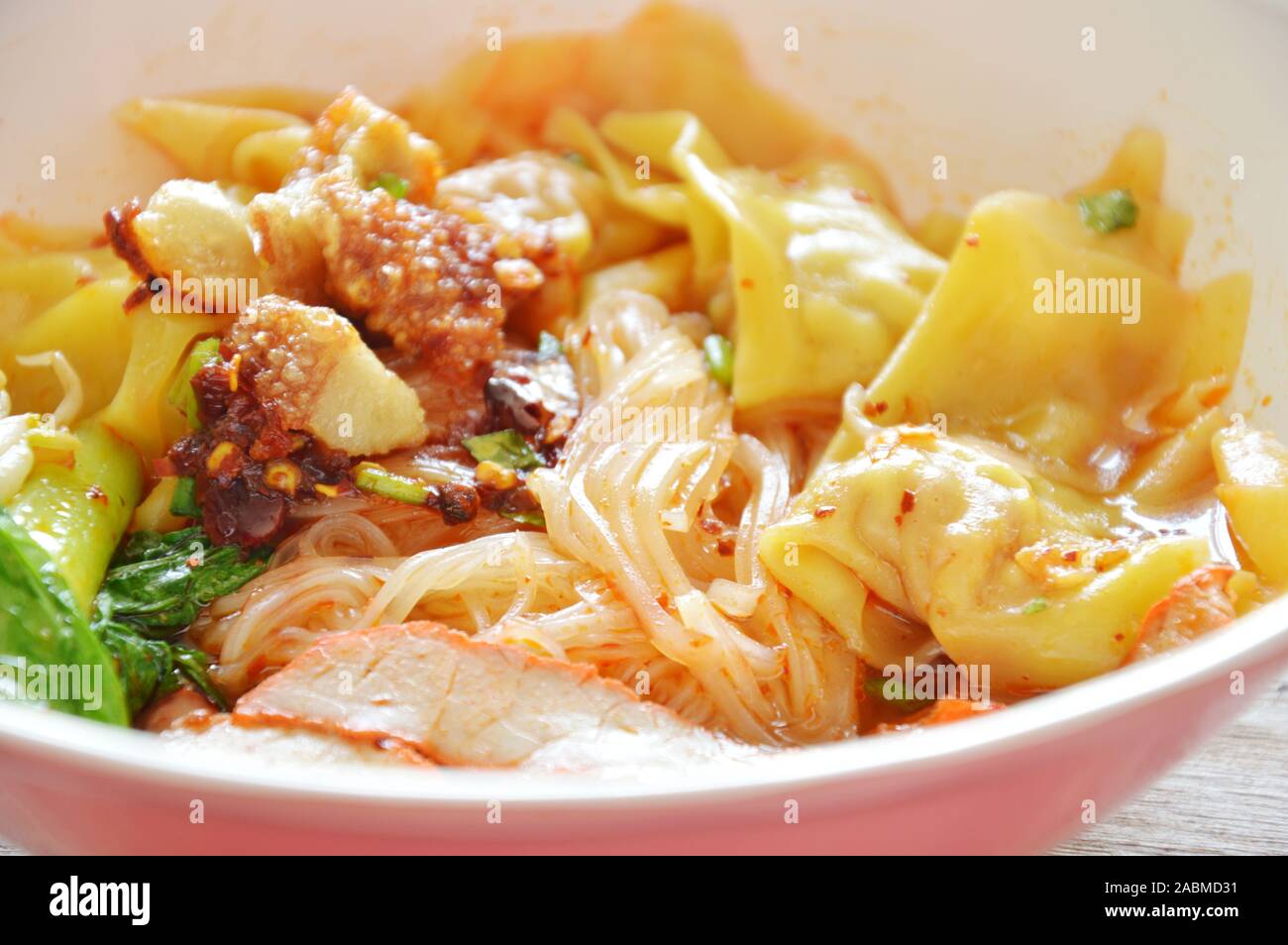 thin rice noodle topping dumpling and slice barbecue pork in soup Stock