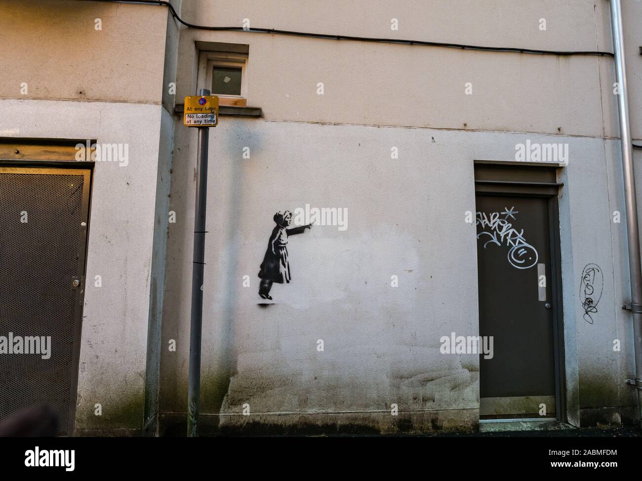 Tron Square, Edinburgh, Scotland, United Kingdom, 28th November 2019. A stencil of a young girl pointing on a wall in a quiet narrow cobbled lane. A number of Banksy style stencil images have appeared around the city over the last year but it is unclear whether they are real or copycats Stock Photo