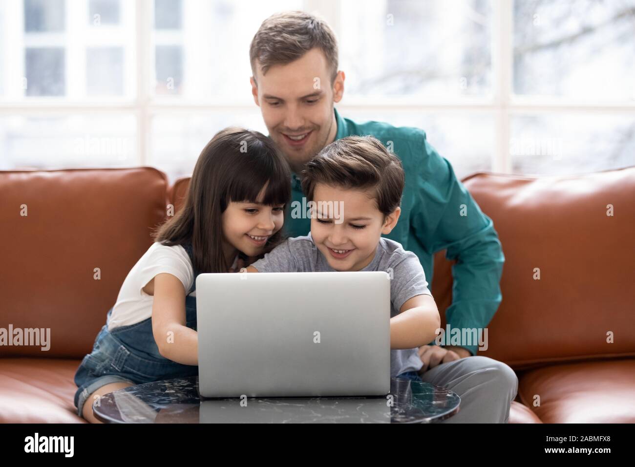 Happy father have fun using laptop with little kids Stock Photo - Alamy
