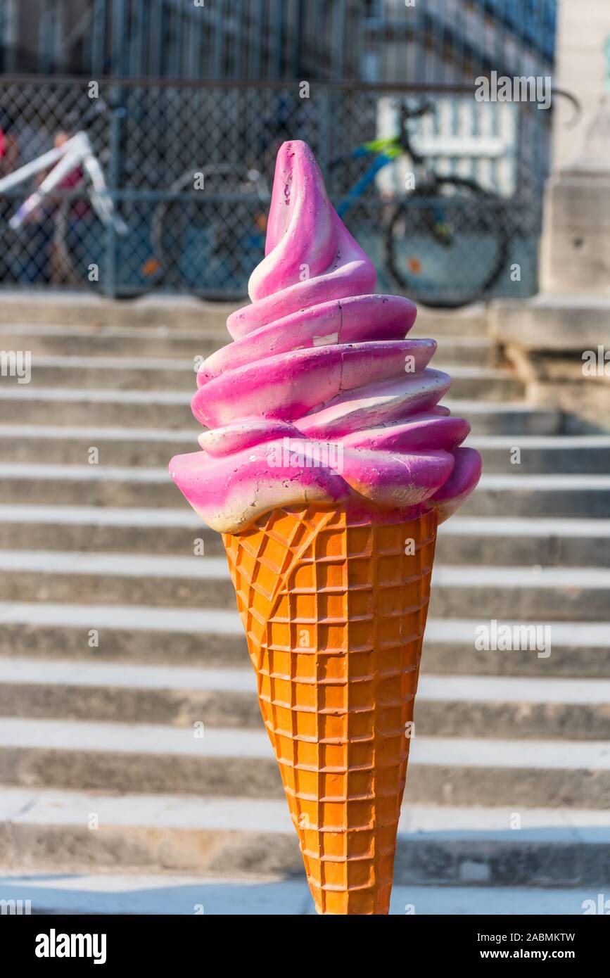 A strawberry ice Cream Cone statue in front of stall at the amusement park of  Tuileries gardens  in Paris, France Stock Photo