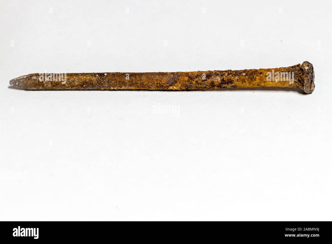 rusty nail covered with a brown oxidant on a white background Stock Photo