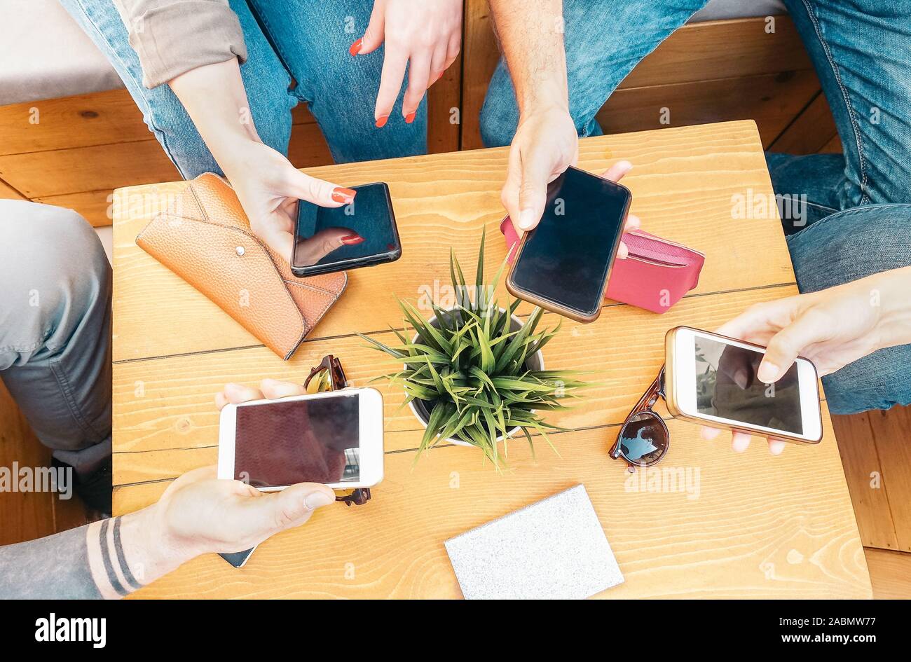 Millennial friends using their mobile smart phones in bar - Young people connecting on new trends social networks Stock Photo