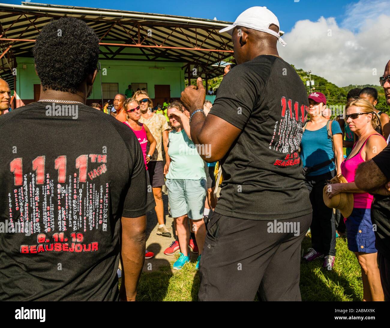 Hash House Harriers Running Event in Happy Hill, Grenada. Wearing a black anniversary t-shirt, the Hash Mouth explains the rules and some of the special features of today's track Stock Photo