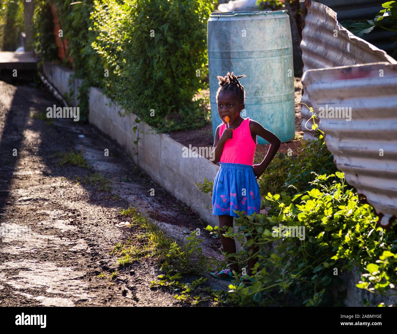 Girl with lolly in Happy Hill, Grenada. Lollies convince even the shyest spectators of the hash run Stock Photo