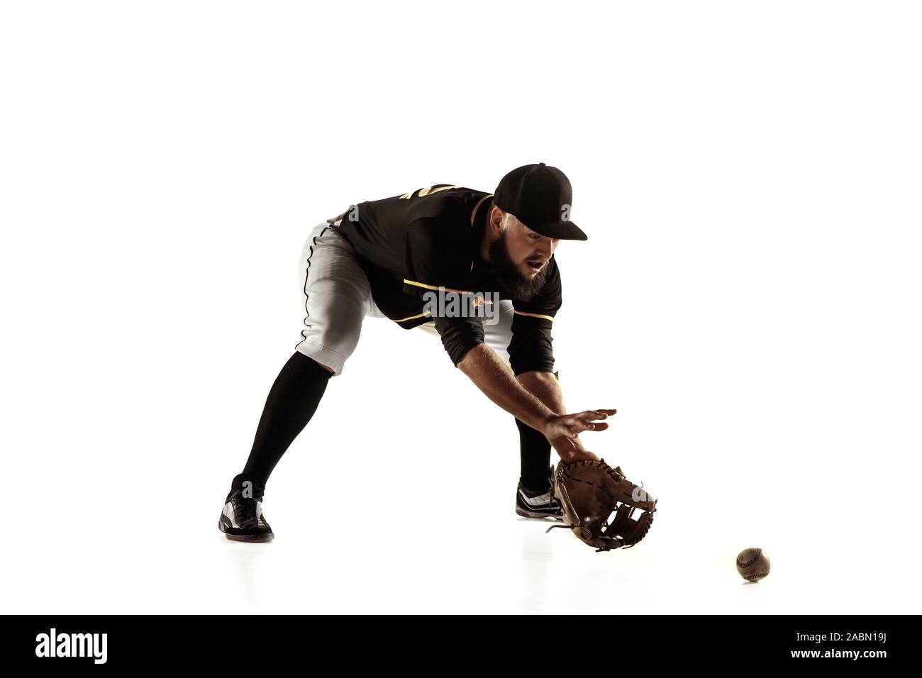 Baseball player, pitcher in a black uniform practicing and training  isolated on a white background. Young professional sportsman in action and  motion. Healthy lifestyle, sport, movement concept Stock Photo - Alamy
