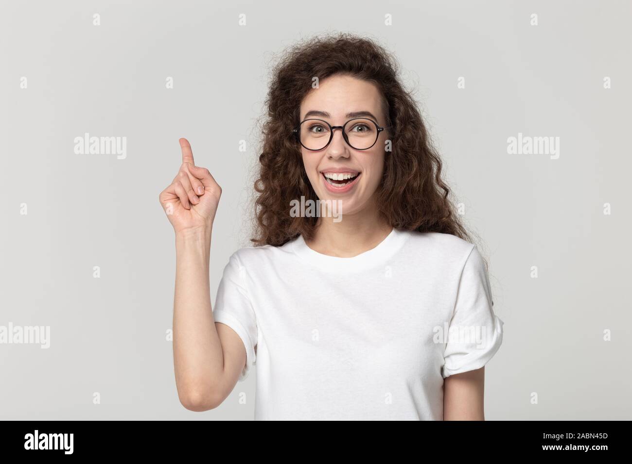 Happy millennial girl raise finger catching interesting idea Stock Photo