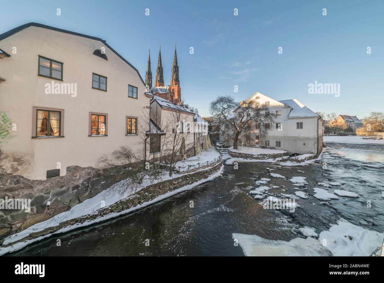 Old mill at Kvarnfallet in the Fyris river with the Cathedral (Domkyrkan) in the background in the winter. Uppsala, Sweden, Scandinavia Stock Photo