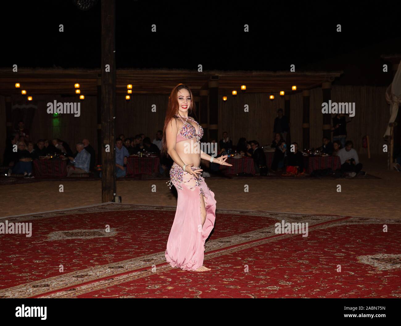 A belly Dancer performs during an Arabian Adventures Desert Safari in the Sahara Desert, Dubai, UAE Stock Photo