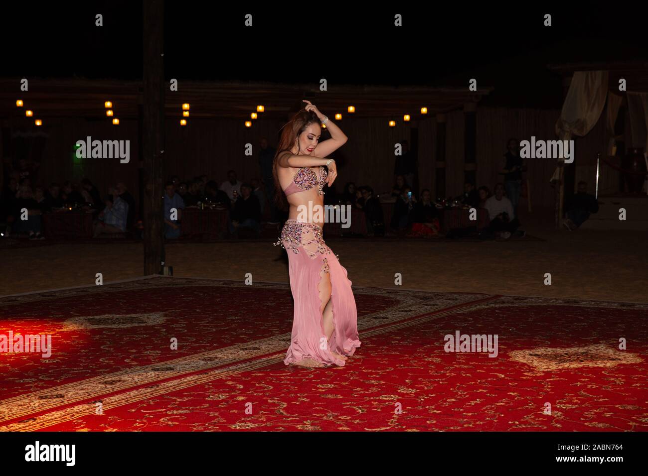 A belly Dancer performs during an Arabian Adventures Desert Safari in the Sahara Desert, Dubai, UAE Stock Photo