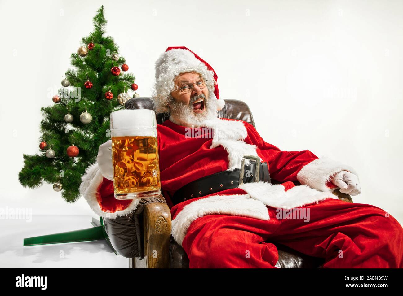 Christmas tree and santa claus drinking beer hires stock photography