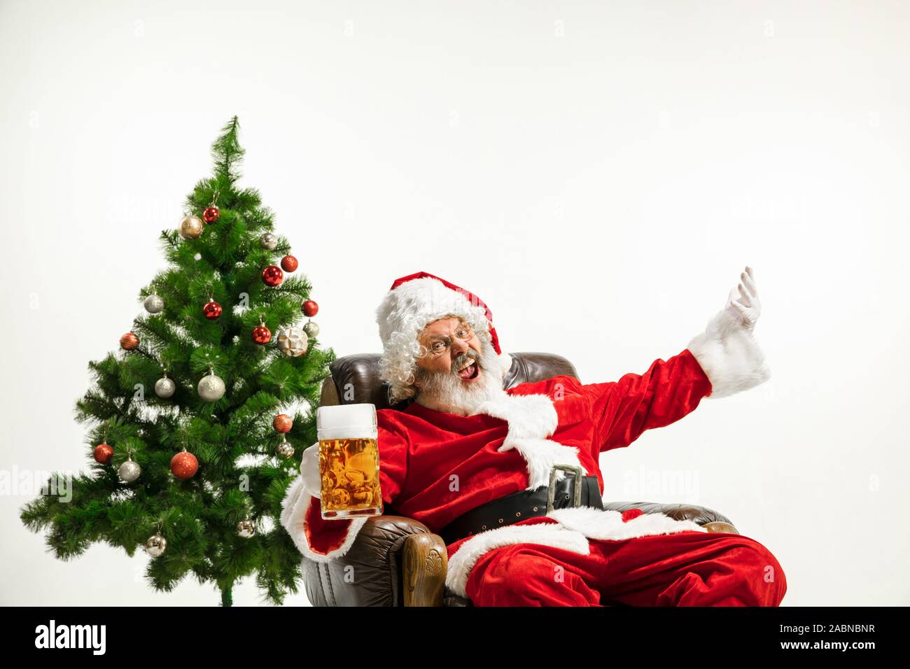 Christmas tree and santa claus drinking beer hires stock photography