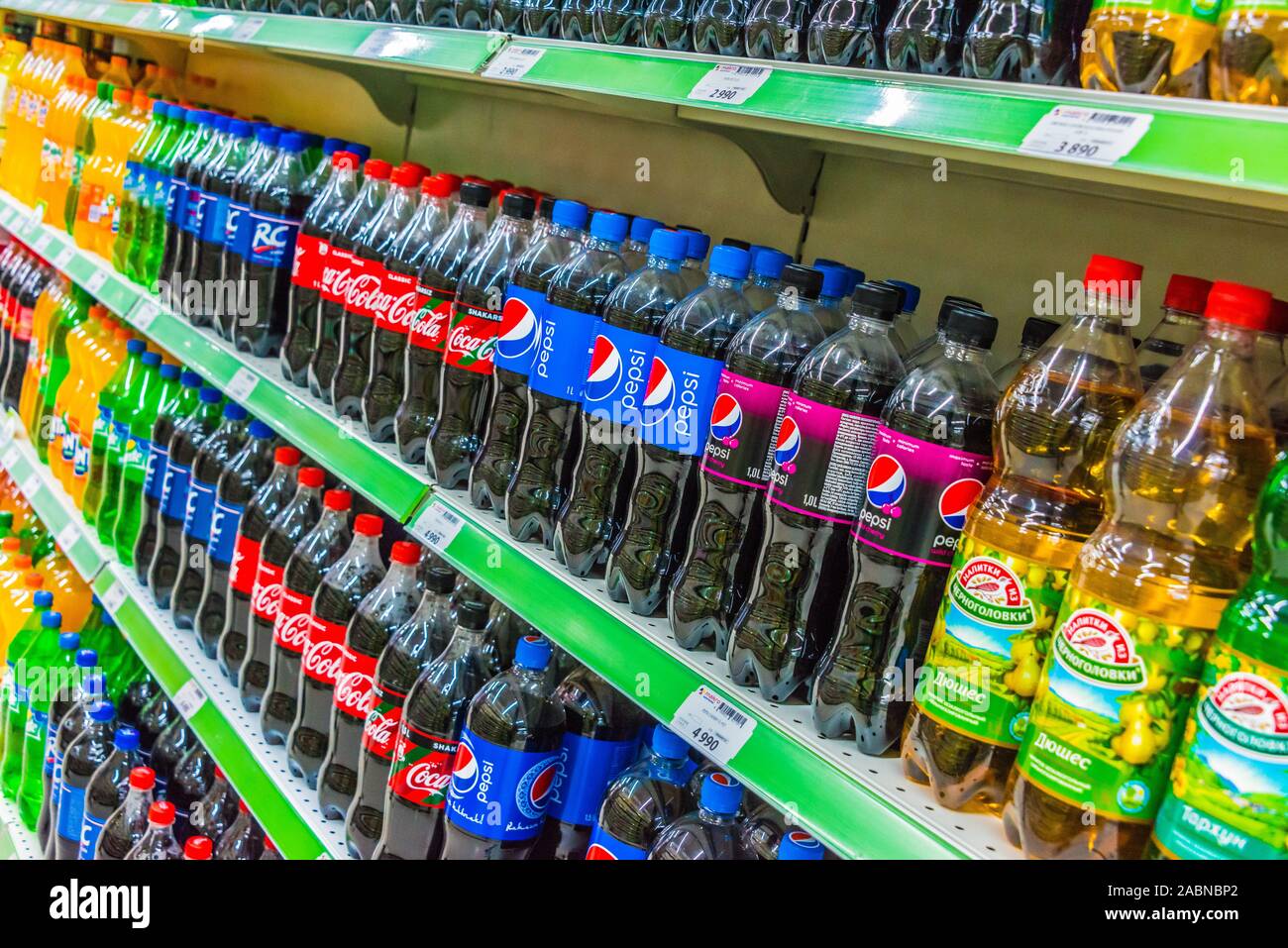 TASHKENT, UZBEKISTAN - MAY 12, 2019: Bottles with popular carbonated soft drinks displayed on the shelf in supermarket Stock Photo