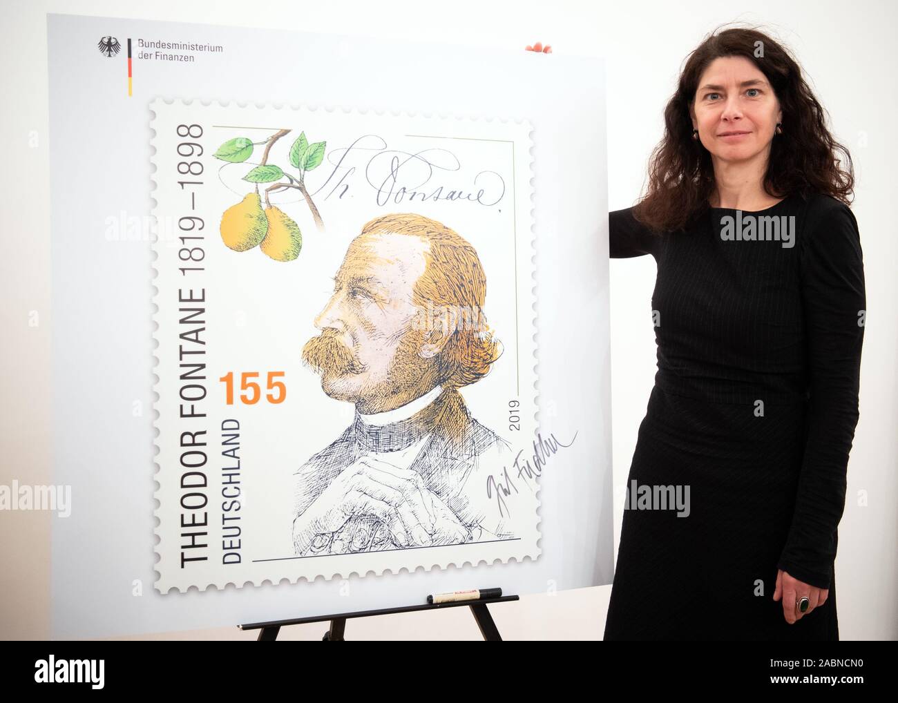 Neuruppin, Germany. 28th Nov, 2019. The Leipzig artist Grit Fiedler, designer of the stamp '200. birthday Theodor Fontane', stands next to an oversized expression after the presentation of the stamp. The portrait drawing is by the Kleinmachnoiwer graphic artist and draughtsman Rainer Ehrt. The stamp will be available in Deutsche Post sales outlets from 05.12.2019 and has a value of 155 cents. Credit: Soeren Stache/dpa/Alamy Live News Stock Photo