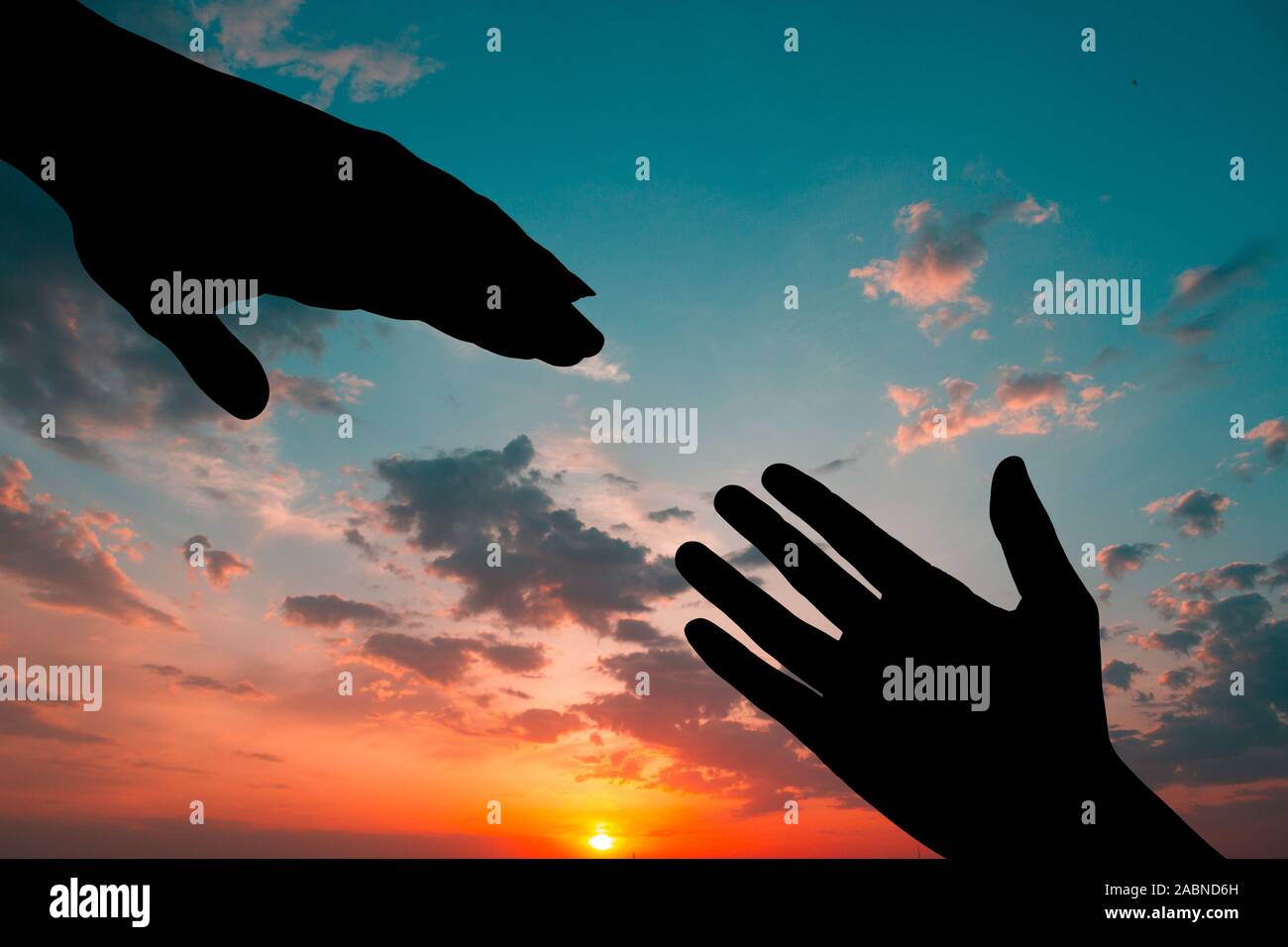 Silhouette of two hands over sunset sky background Stock Photo - Alamy