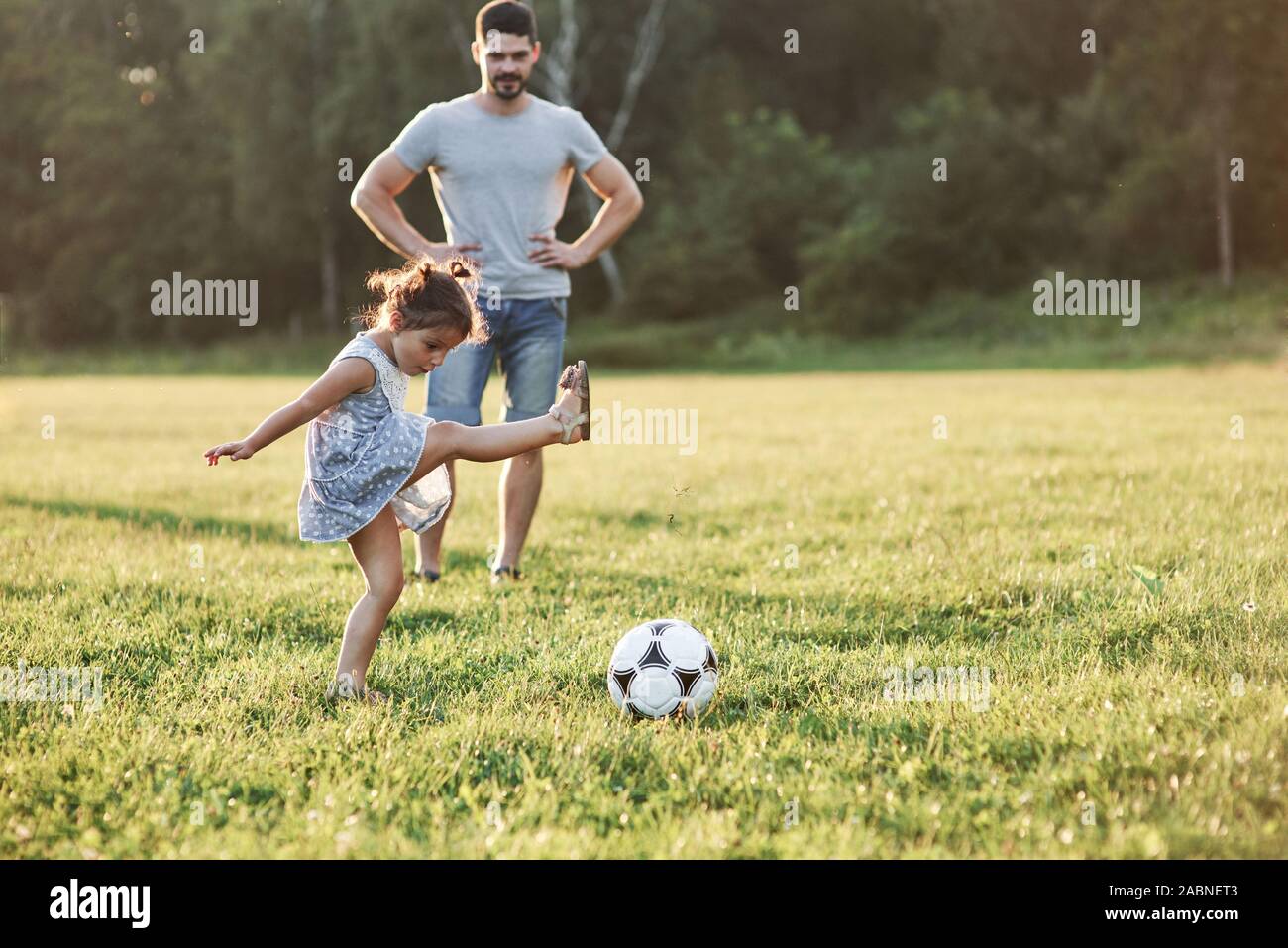 Научи папу играть. Папа и дочка играют в футбол. Семья играет в футбол. Папа с дочкой играет мяч. Папа мама дочка играют в футбол.