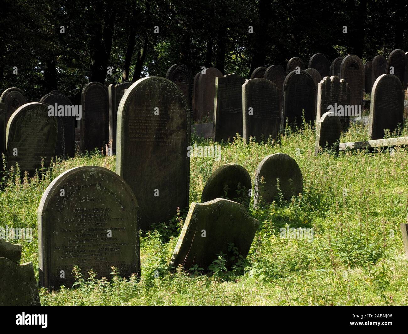 overlapping serried ranks of ancient carved headstones on graves in churchyard at Bradfield, Sheffield, South Yorkshire, England, UK Stock Photo