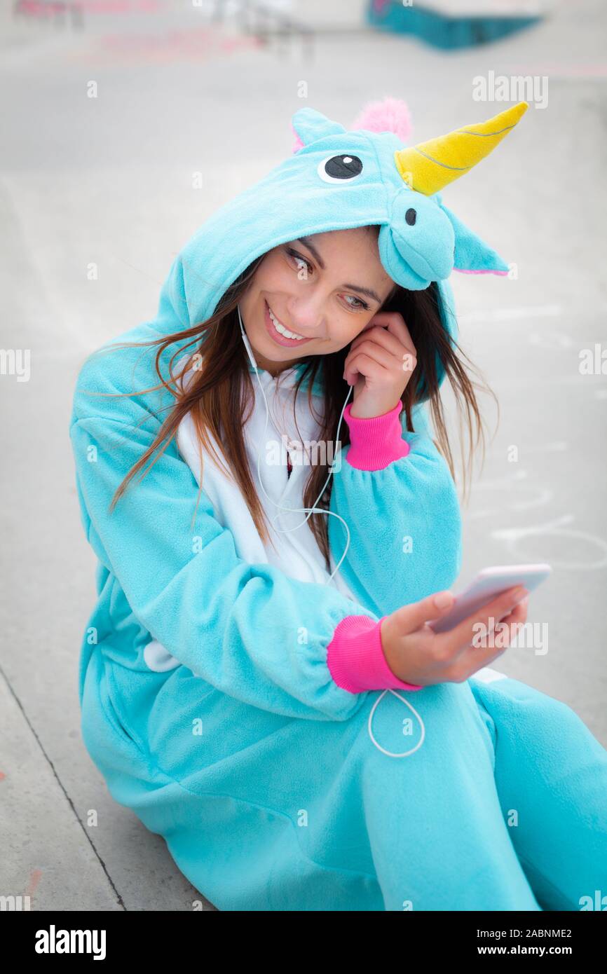 beautiful young woman wearing turquoise unicorn onesie in urban environment  Stock Photo - Alamy