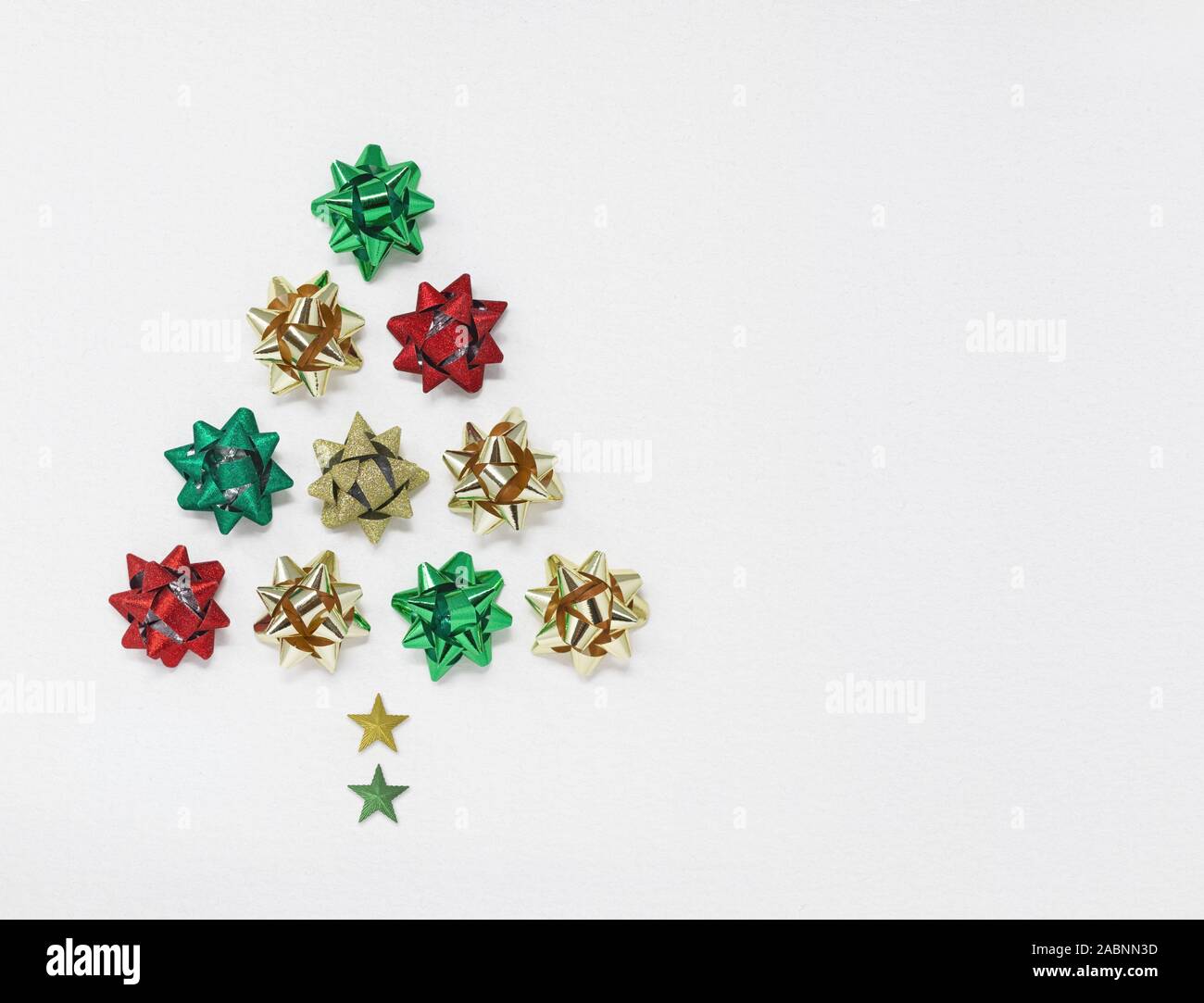 Christmas tree shape made of bows and stars, isolated on a white background with copy space Stock Photo