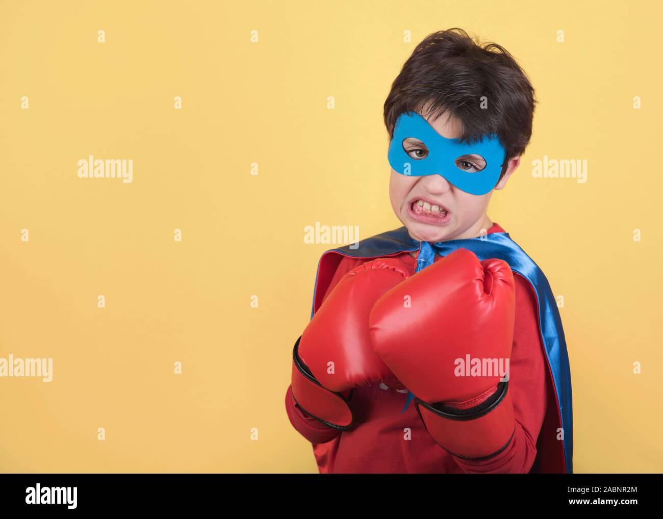 superhero, Portrait of boy in superhero costumeon yellow background Stock Photo