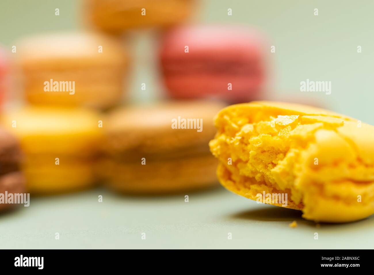 Colored tasty macaroons over a green background. Stock Photo