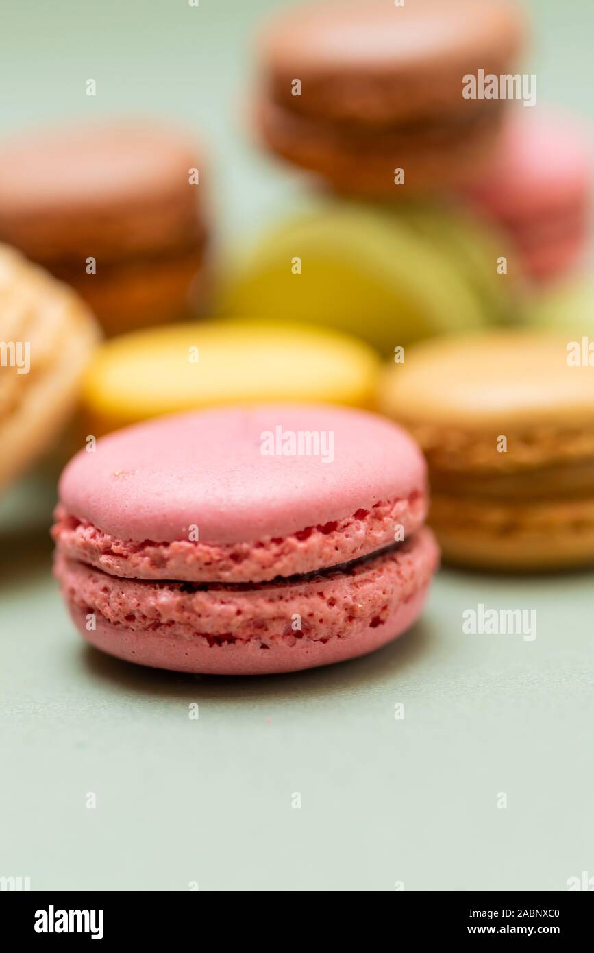 Colored tasty  macaroons over a green background. Stock Photo