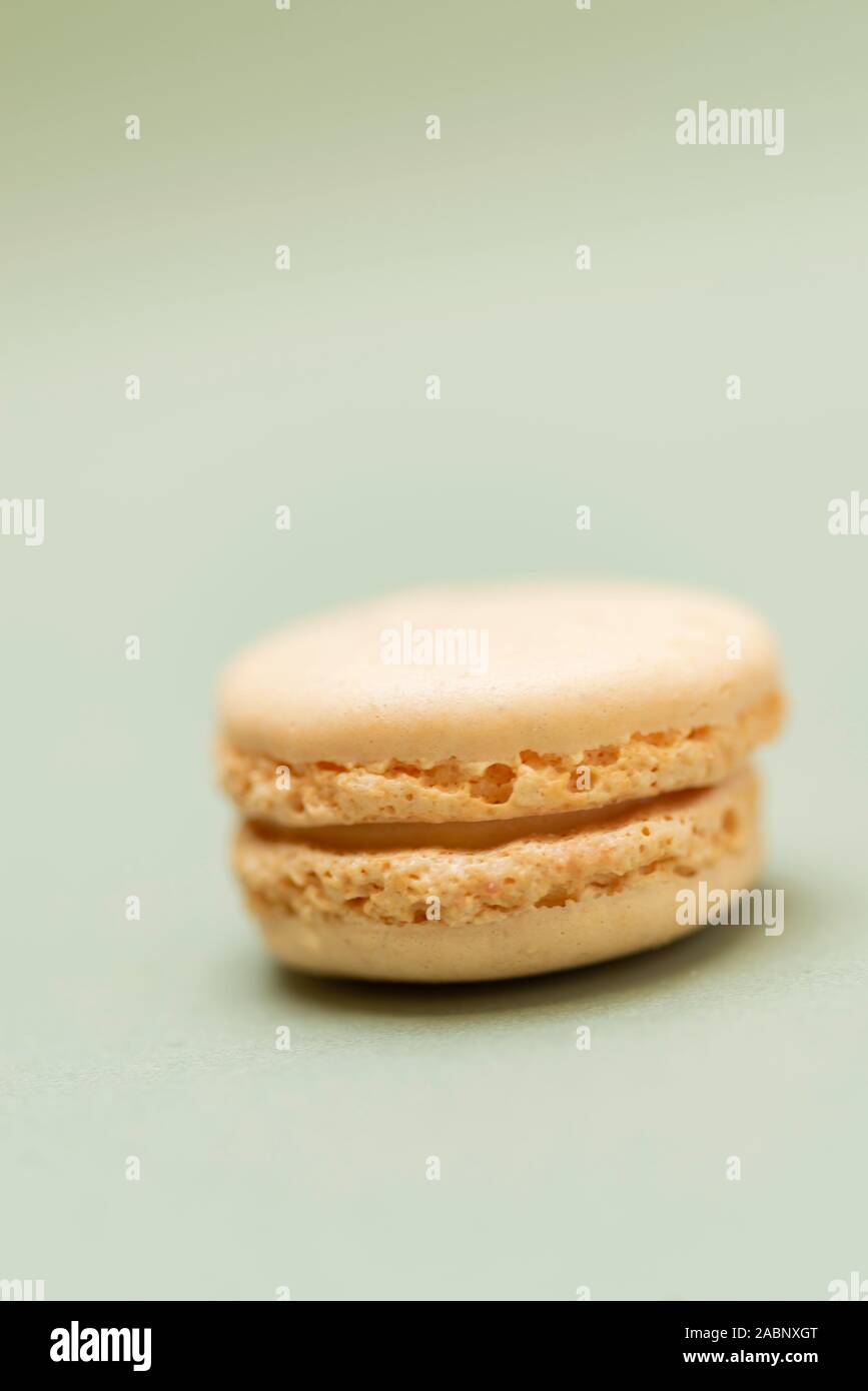 Colored tasty macaroons over a green background. Stock Photo