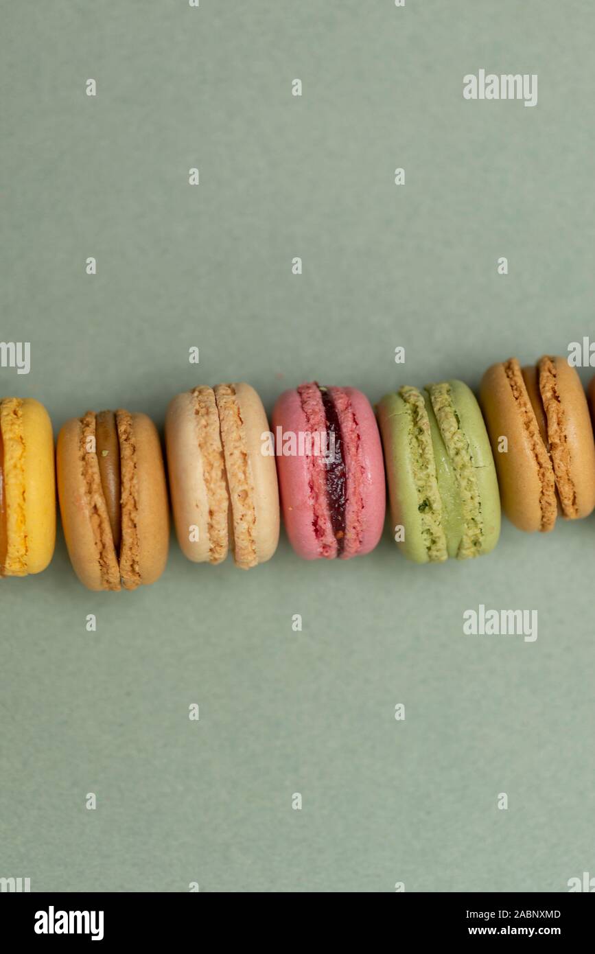Colored tasty  macaroons over a green background. Stock Photo