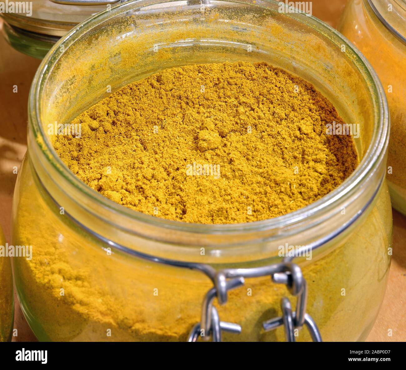 yellow curry powder in the glass jar for sale at grocery Stock Photo