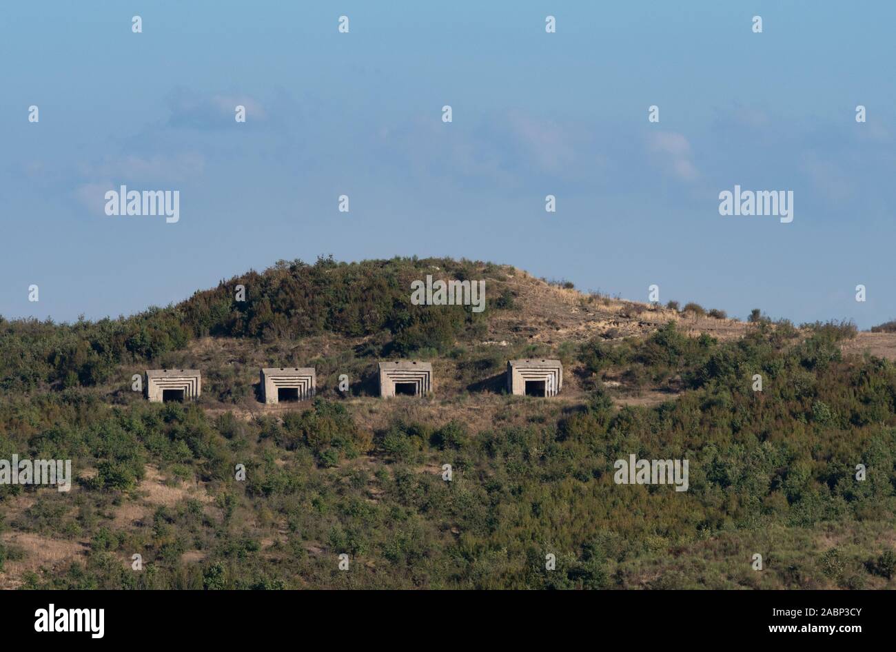 Four concrete bunkers built into a hill during Enver Hoxha's rule in the Soviet era in Albania. Stock Photo