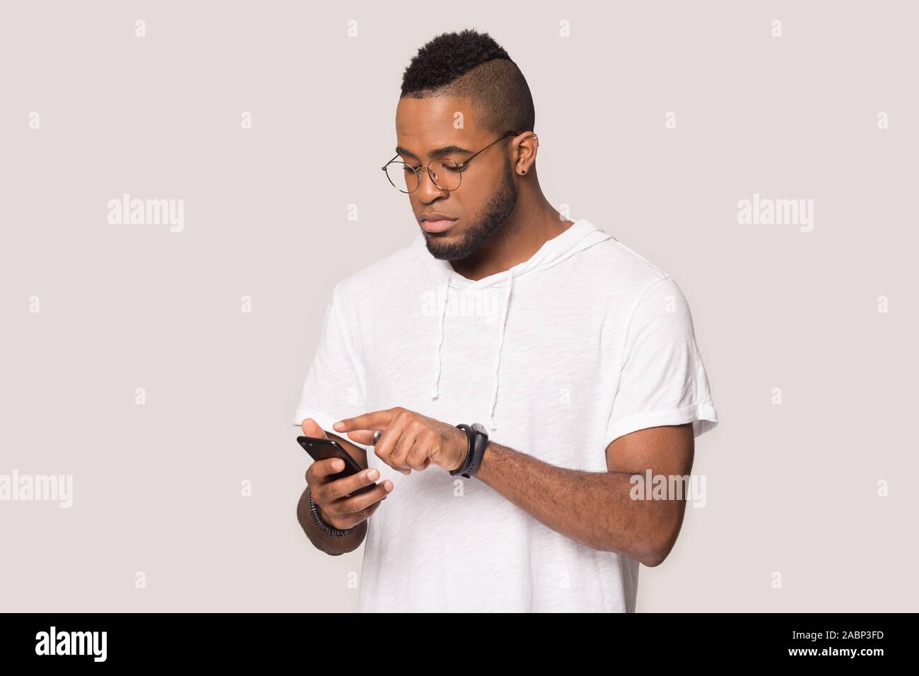 Serious African American man using phone, looking at screen Stock Photo