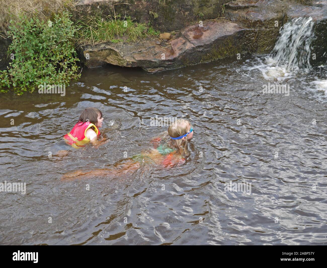 Children swimming in the river above Hebden Bridge in West Yorkshire Stock Photo