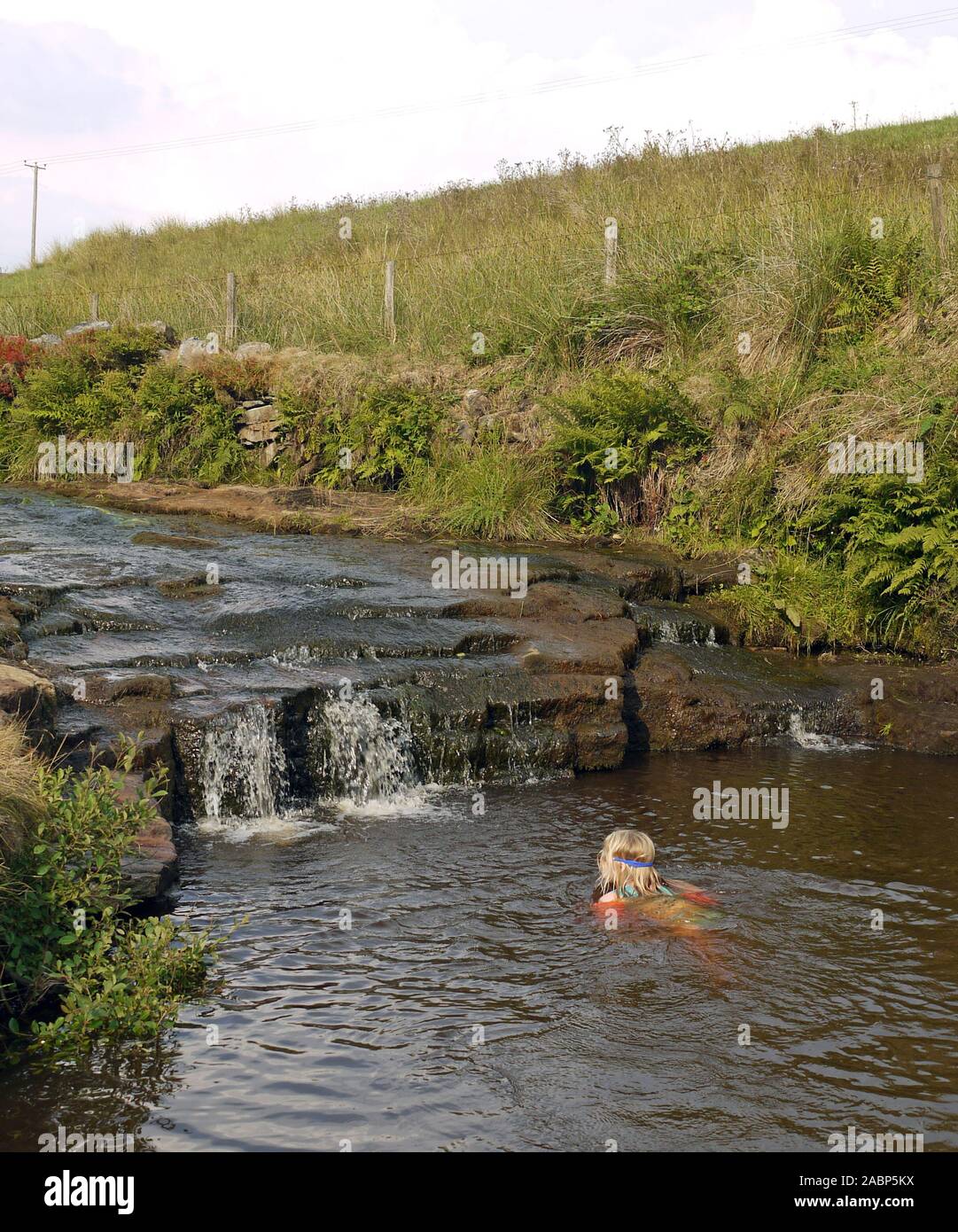 Children swimming in the river above Hebden Bridge in West Yorkshire Stock Photo