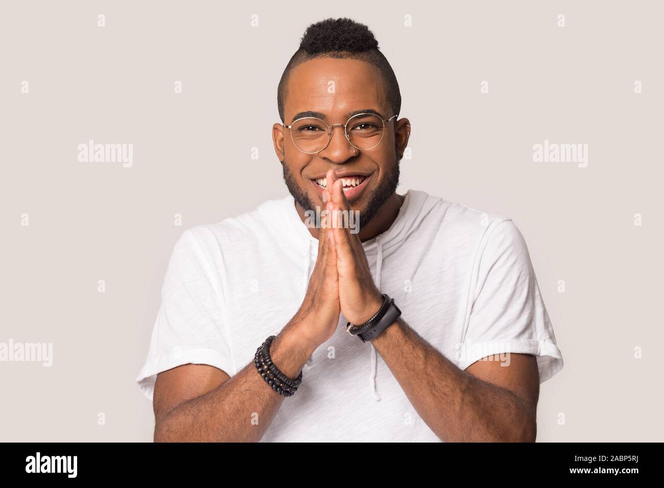 Smiling African American man join hands in anticipation, expectation Stock Photo