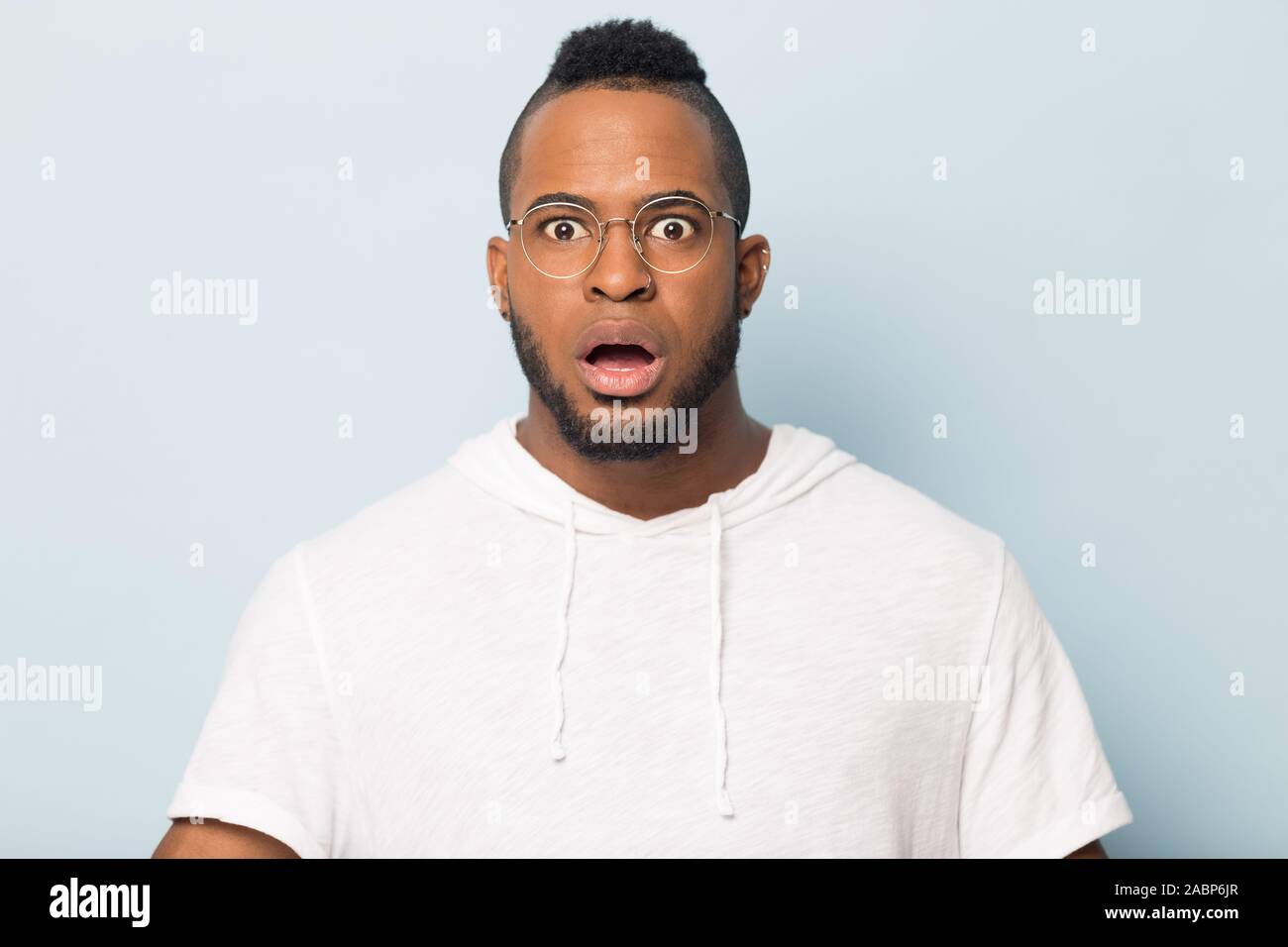 Shocked scared African American man in glasses looking at camera Stock Photo