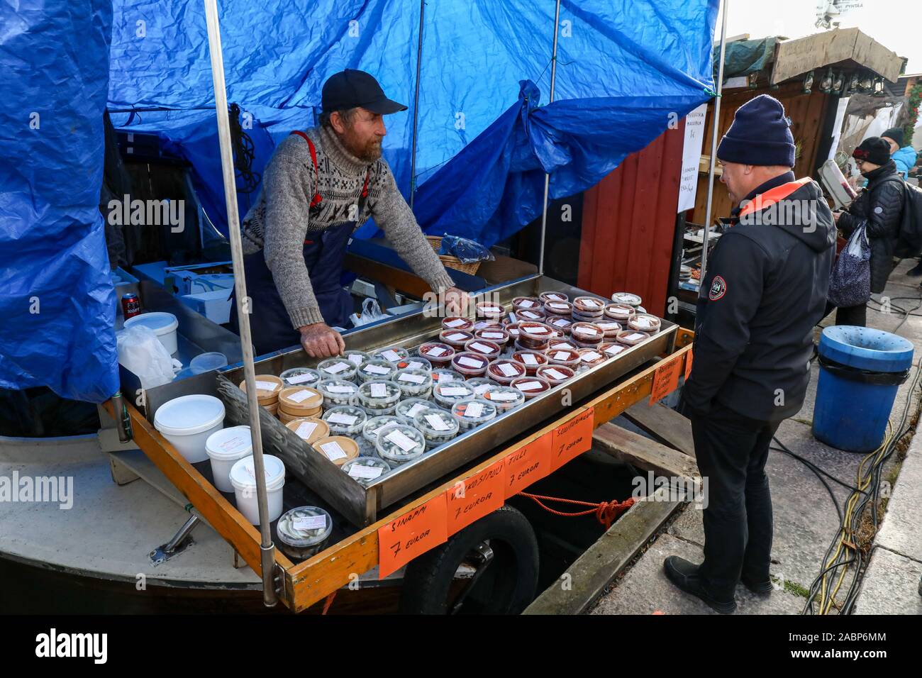 Fisherman selling herring related products from his boat at Baltic Herring Fair by Market Square in Helsinki, Finland Stock Photo