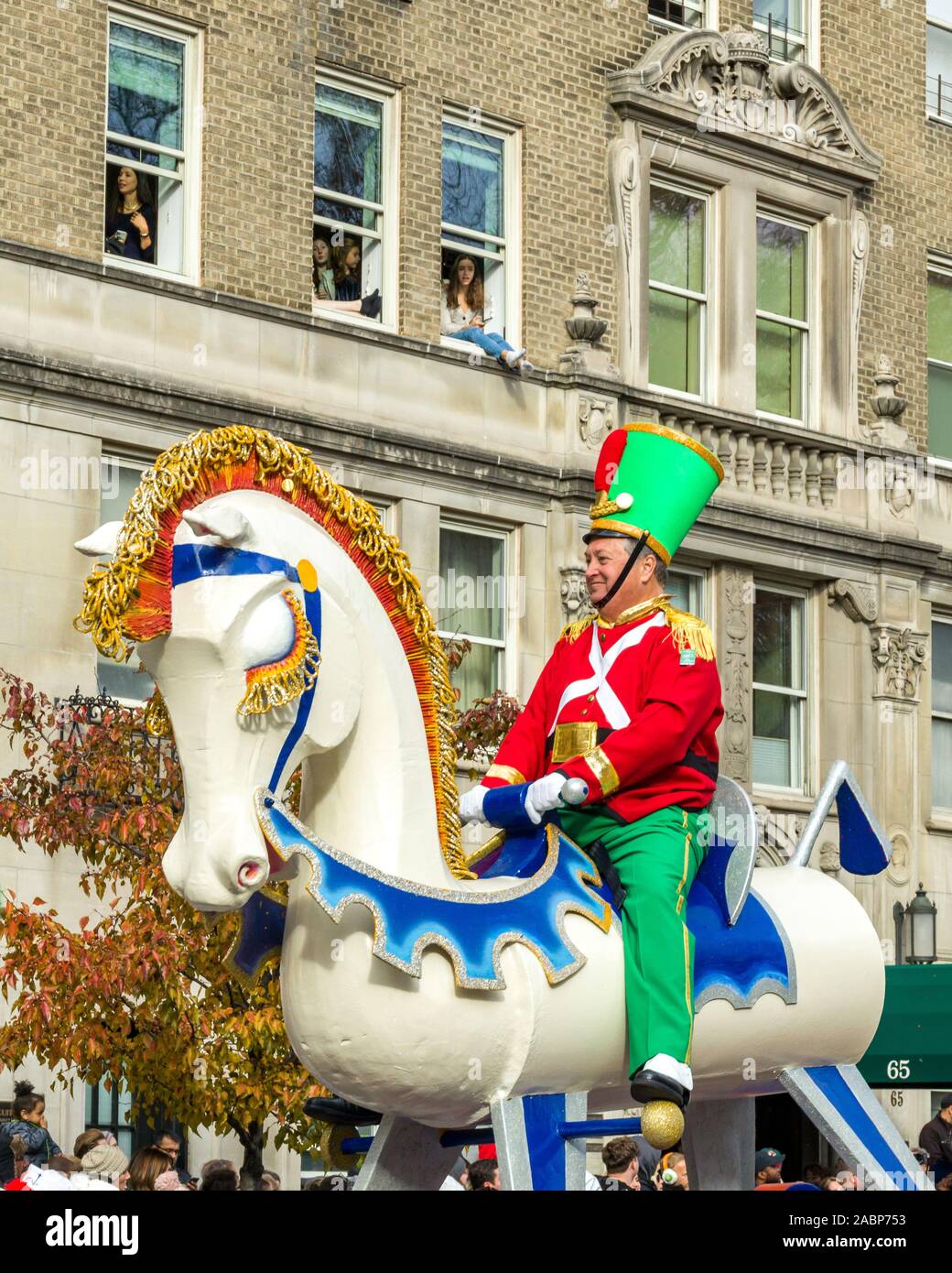New York, USA. 28th Nov, 2019. People watch the Rocking Horse float from their building in Central Park West during Macy's Thanksgiving Parade in New York City. Credit: Enrique Shore/Alamy Live News Stock Photo