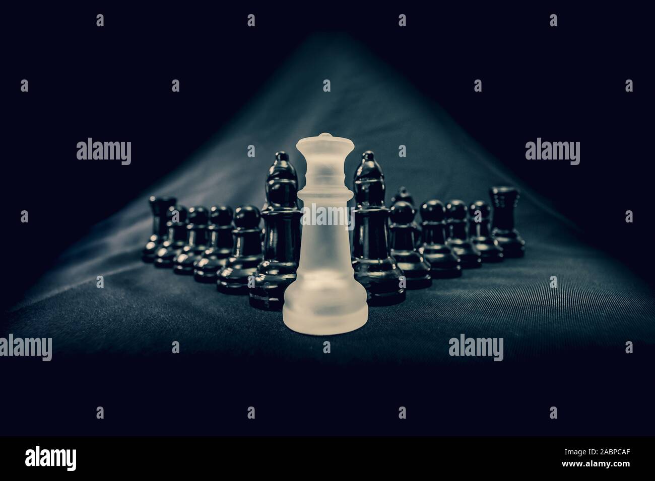 White queen chess piece leading opposing side against her king Stock Photo