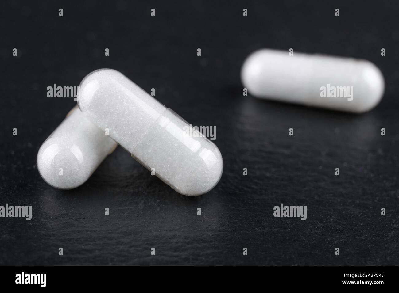 white capsules of nutritional supplement msm, sulfur on black