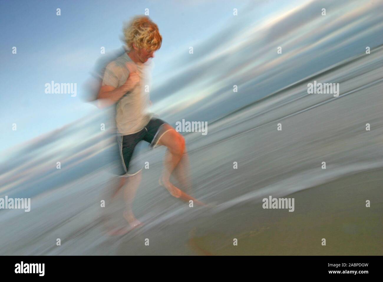 Junger Mann rennt am Strand Stock Photo
