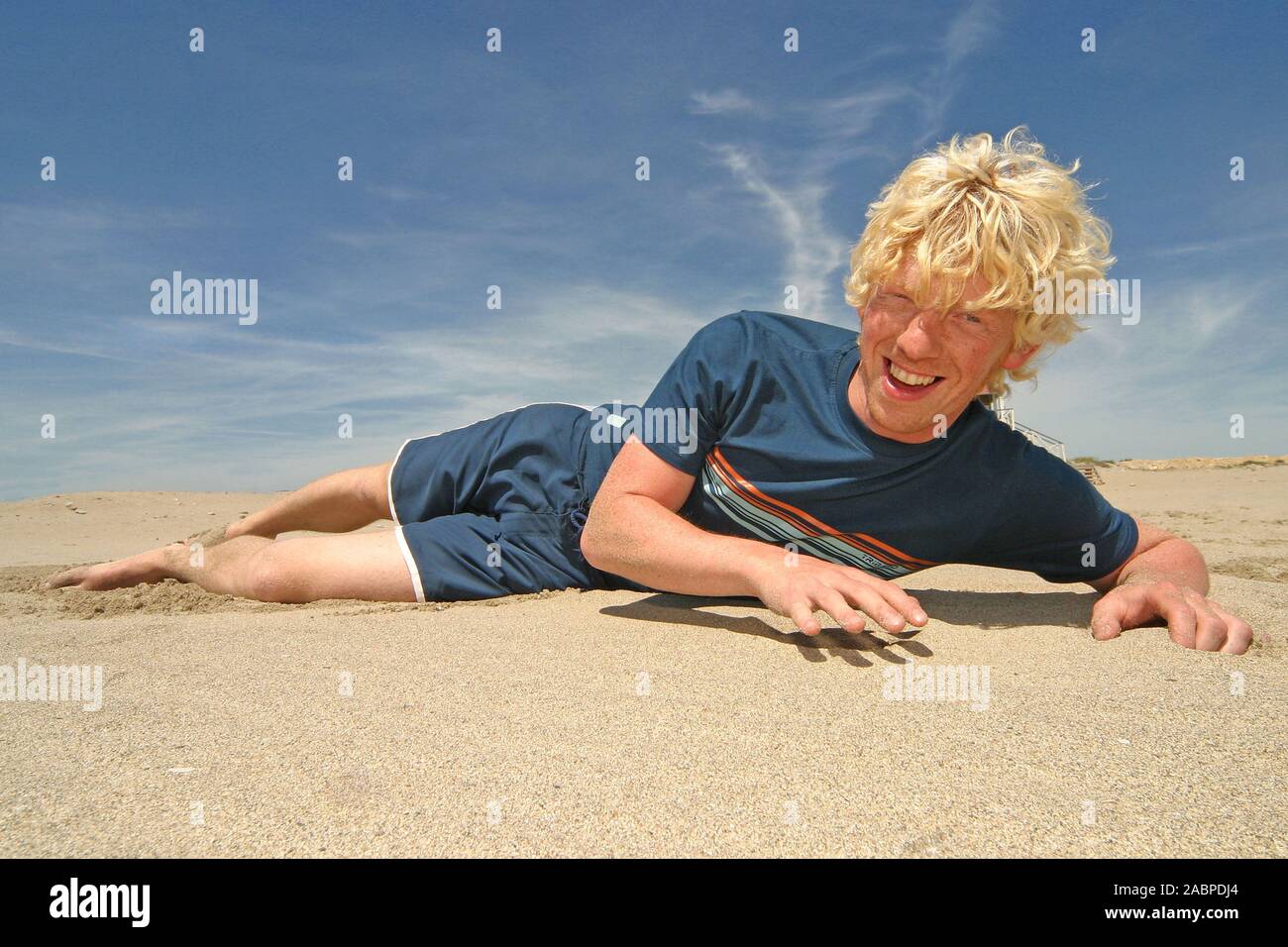Junger Mann liegt am Strand Stock Photo