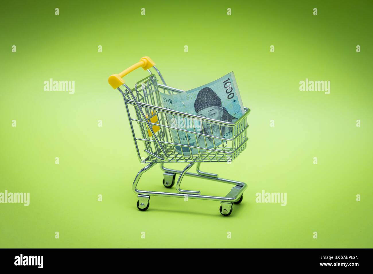 Miniature shopping trolley with Korean money, Won. The concept of shopping and the power of the economy. Stock Photo