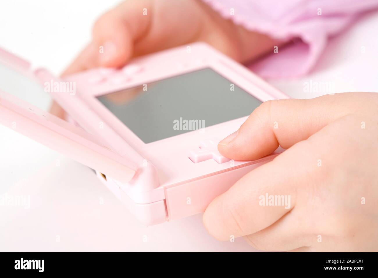 Maedchen rosa gekleidet mit rosa Gameboy Stock Photo