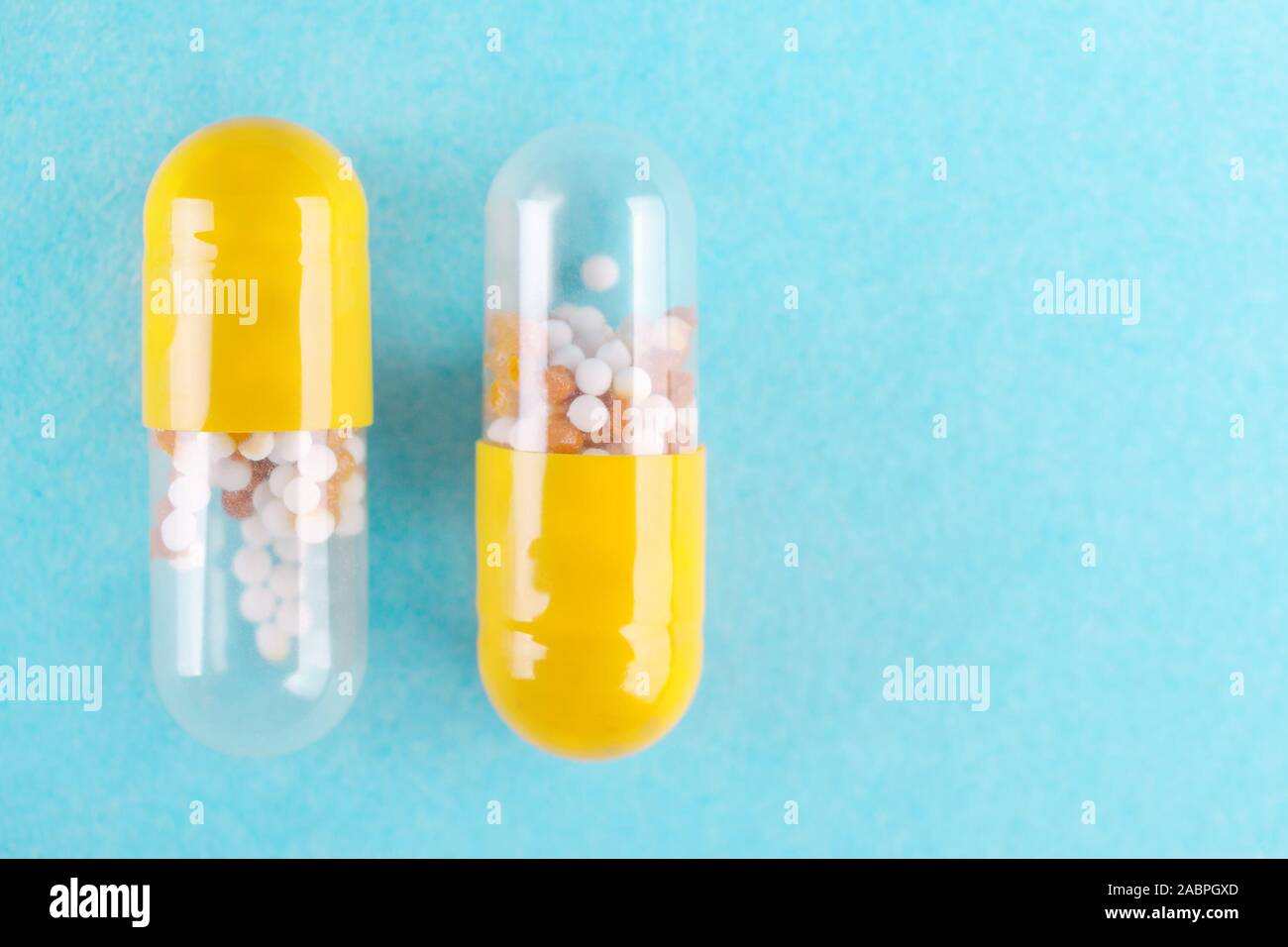 two medicine capsules on blue background flat lay Stock Photo