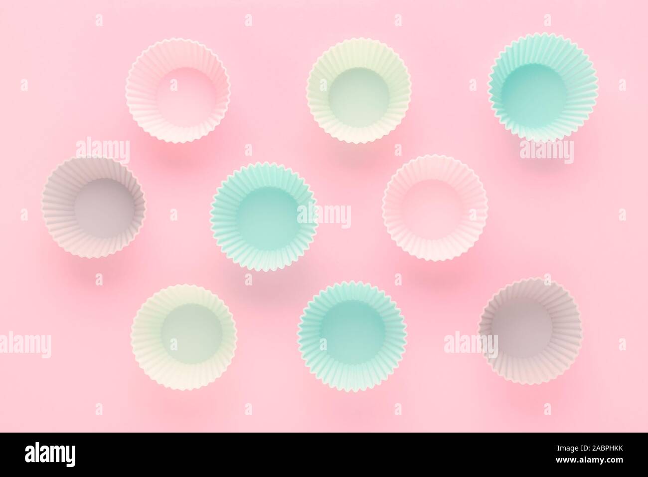 silikone forms for baking muffins and cupcakes on pastel pink background Stock Photo