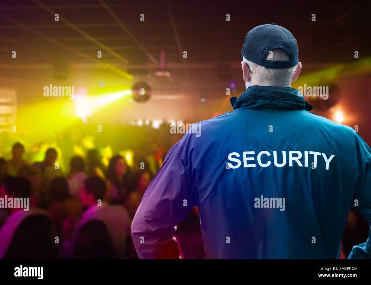 Male Security Officer Wearing Cap Standing In Night Club With His Hands On Hips Stock Photo