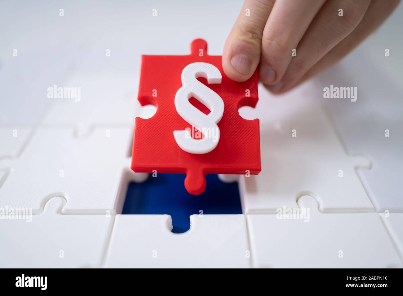 A Person Connecting Last Red Piece With Paragraph Symbol Into Jigsaw Puzzles Stock Photo