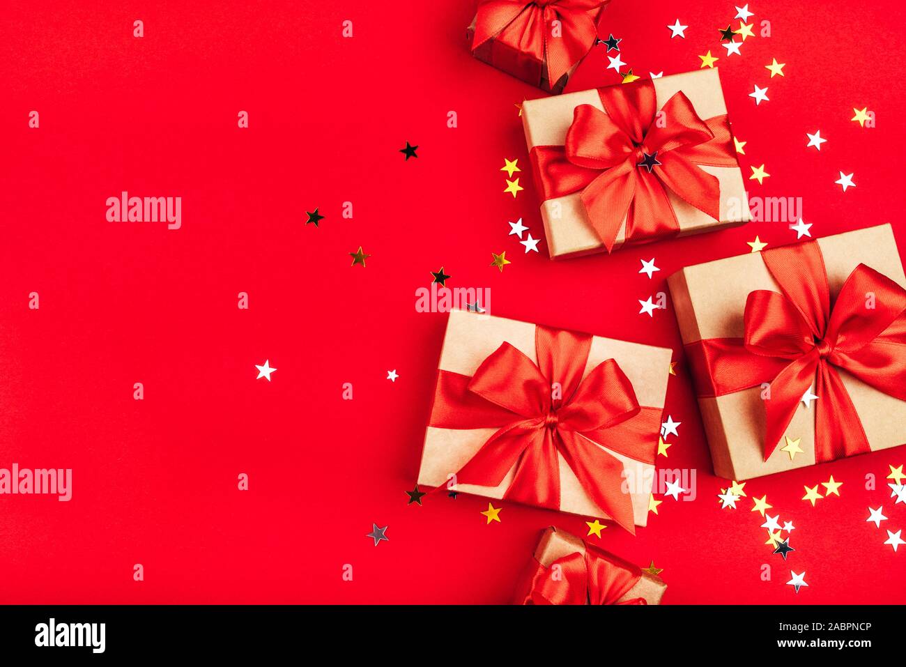 Several gift boxes with bows on a red background. Stock Photo