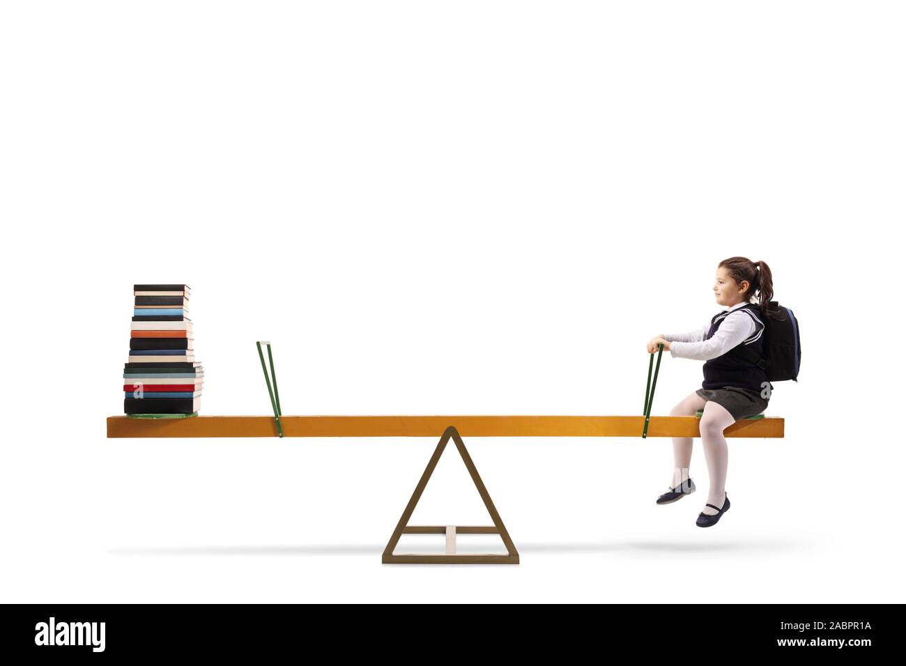 Little schoolgirl sitting on a seesaw across a pile of books isolated ...