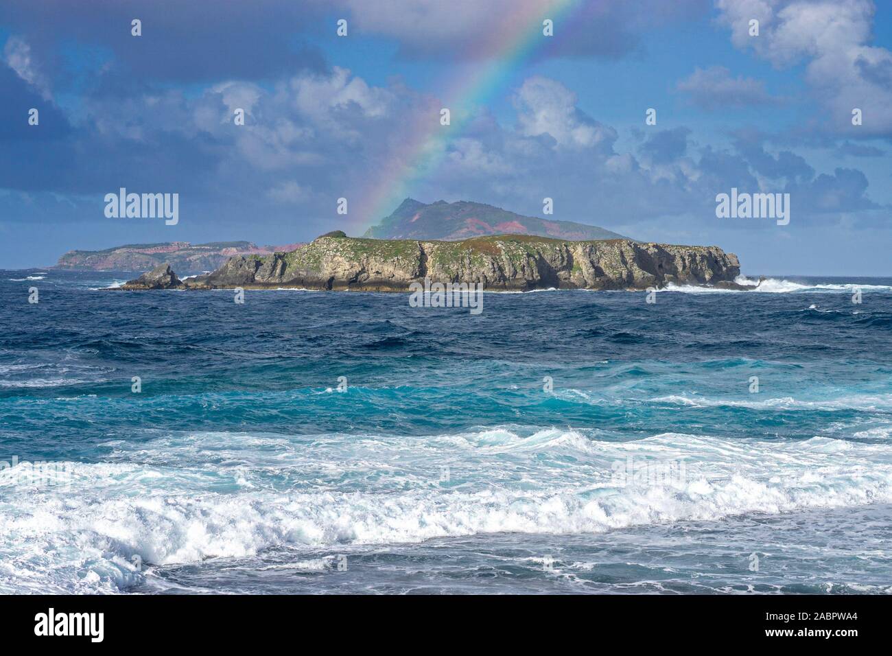 Rainbow over uninhabited Nepean Island about 800 m south of Norfolk Island and 10 ha in area. Its 30-metre cliffs make access difficult and few people Stock Photo