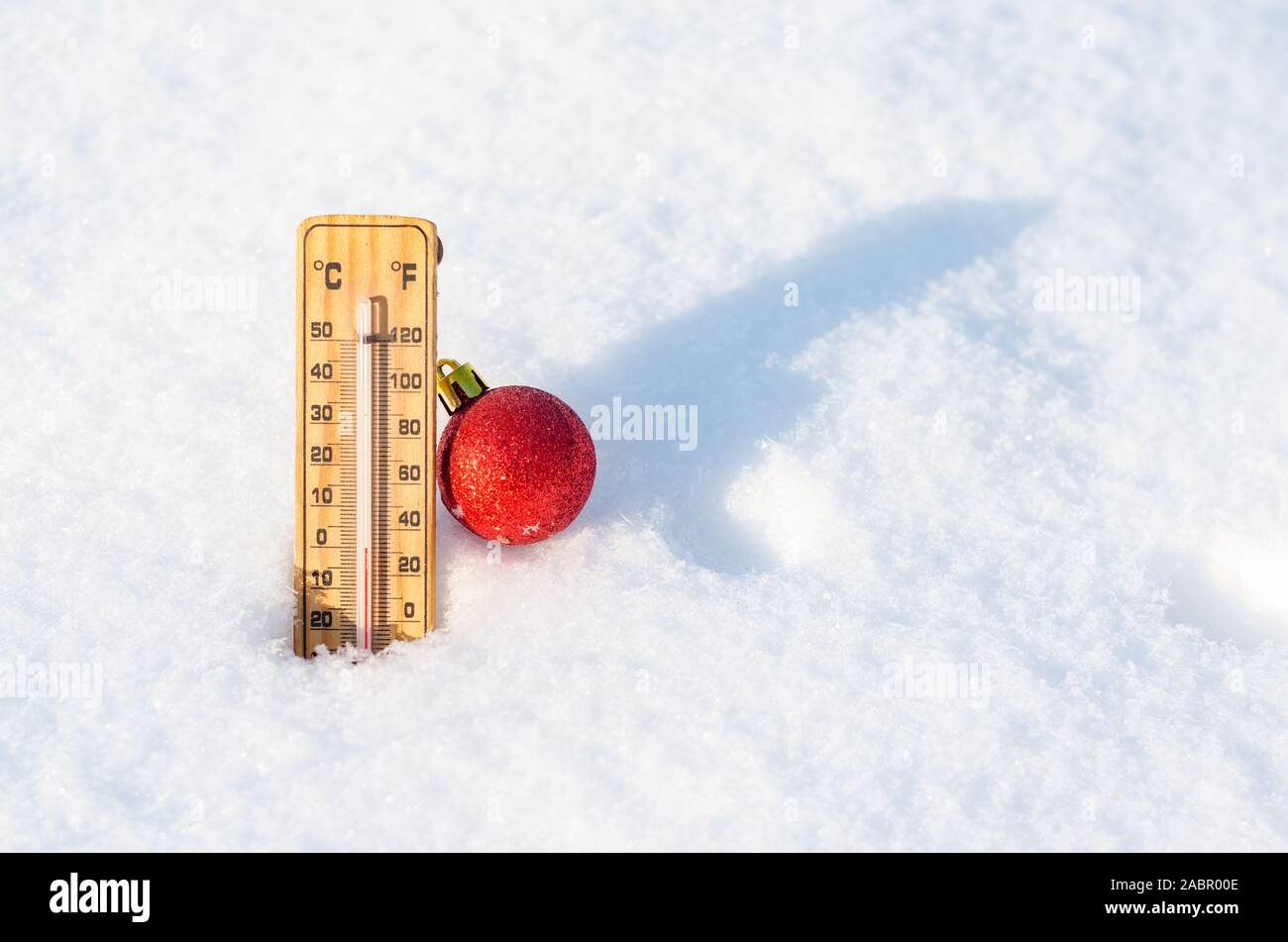 Thermometer in snow indicating temperature 0 degrees .Christmas Ball Ornaments Stock Photo
